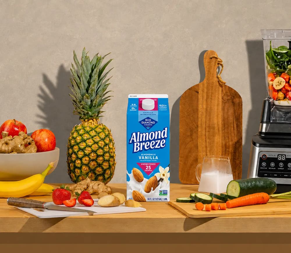 Almond Breeze carton with fruit and cereal on a kitchen table