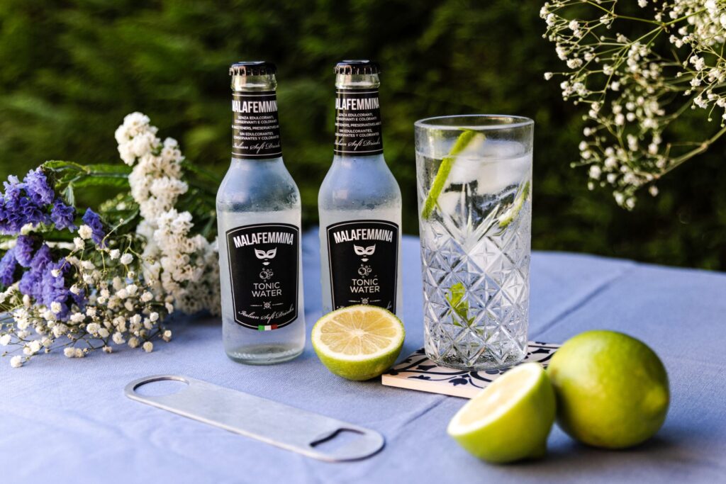Malafemmina tonic water bottles with a gin and tonic and fresh limes